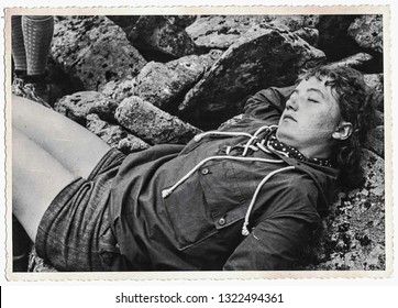 THE CZECHOSLOVAK SOCIALIST REPUBLIC - CIRCA 1970s: Retro photo shows beautiful female tourist having a rest. Female tourist relaxing on rocks. Black white photo. 