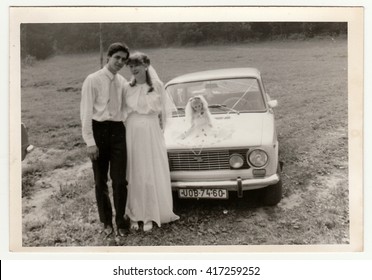 THE CZECHOSLOVAK SOCIALIST REPUBLIC - CIRCA 1970s: Retro Photo Shows Newlyweds And Wedding Car. Black & White Vintage Photography.