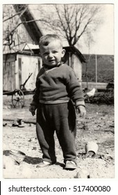 THE CZECHOSLOVAK SOCIALIST REPUBLIC - CIRCA 1970s: Vintage Photo Shows A Small Boy Stands In The Backyard. Retro Black & White  Photography.