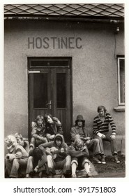 THE CZECHOSLOVAK SOCIALIST REPUBLIC - CIRCA 1980s: Vintage Photo Shows Young Hikers In Front Of The Pub. One Of Them Plays The Guitar.  Antique Black & White Photo.