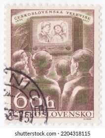 CZECHOSLOVAKIA - 1957 October 19: An 60 Hellers Reddish Brown And Emerald Postage Stamp Showing Family Watching Television. Issued To Publicize The Television Industry