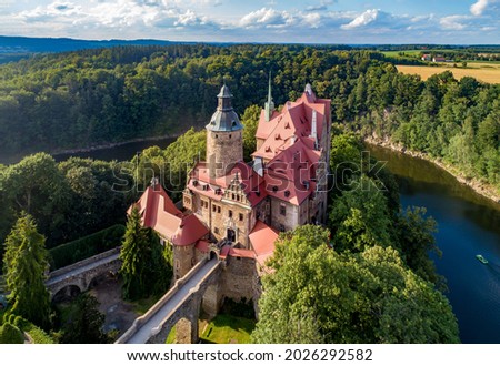 Czocha (Tzchocha) medieval castle in Lower Silesia in Poland. Built in 13th century (the main keep) with many later additions. Aerial view in summer with Kwisa river and tourist boat 