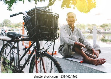 Da Nang, Vietnam - Oct, 2016: Blur Portrait Of Old Veteran Sitting On A Park With His Old Bike.