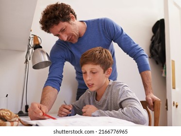 Dad Always Knows The Answer. Shot Of A Teenage Boy Getting Some Study Help From His Father.