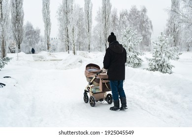 Dad With A Baby Carriage In Winter On The Road