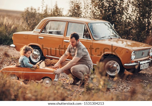 dad and baby are fixing the\
car