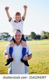 Dad Is The Best Coach. Portrait Of A Father Carrying His Young Son On His Shoulders After A Soccer Game.