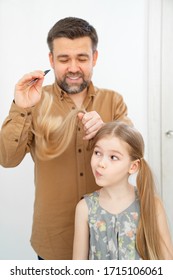 Dad Brushing Hair, Makes Ponytails Her Little Daughter. Father Combing Hair. Care In The Family.