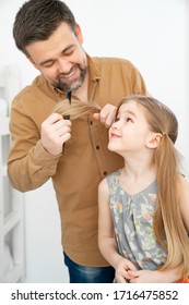 Dad Brushing Hair, Makes Ponytails Her Little Daughter. Father Combing Hair. Care In The Family.