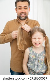 Dad Brushing Hair, Makes Ponytails Her Little Daughter. Father Combing Hair. Care In The Family.