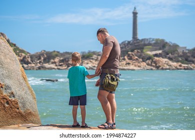 Dad Care Son Near Sea, Walk Spend Time Together Explore New. Man Hold Kid Hand. Lighthouse Background Symbol Of Individual Consciousness, Raising Boy, Father Family Union Influence In Happy Child Live