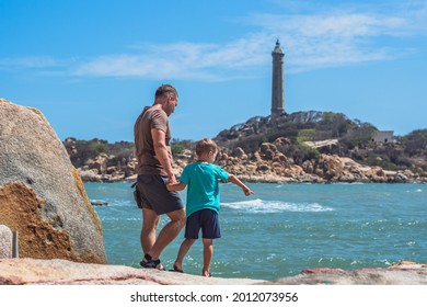 Dad Care Son Near Sea, Walk Spend Time Together Explore New. Man Hold Kid Hand. Lighthouse Background Symbol Of Individual Consciousness, Raising Boy, Father Family Union Influence In Happy Child Live