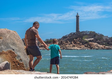 Dad Care Son Near Sea, Walk Spend Time Together Explore New. Man Hold Kid Hand. Lighthouse Background Symbol Of Individual Consciousness, Raising Boy, Father Family Union Influence In Happy Child Live