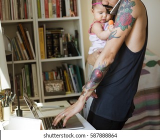 Dad Carrying His Baby And Busy Using Computer Laptop