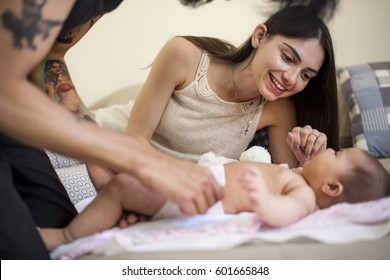 Dad Changing Diaper To His Baby On The Bed