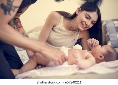 Dad Changing Diaper To His Baby On The Bed