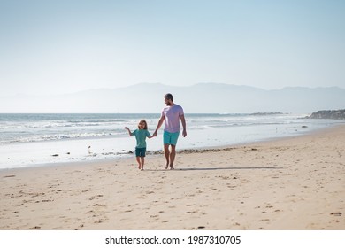 Dad And Child Having Fun Outdoors. Father And Son Walking On Summer Beach. Dad And Child Holding Hands And Walk Together.