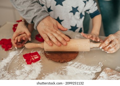 Dad and child son together with hands using rolling pin roll out dough on table at home, cozy kitchen, happy hours together, teamwork. Joint hobby. Happy family. Christmas moment, single father
