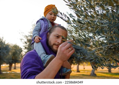 Dad and child are walking in the autumn park. Mediterranean climate. - Shutterstock ID 2258684349