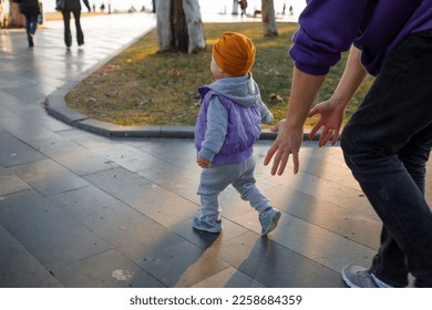 Dad and child are walking in the autumn park. Mediterranean climate. - Shutterstock ID 2258684359