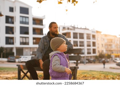 Dad and child are walking in the autumn park. Mediterranean climate. - Shutterstock ID 2258684367