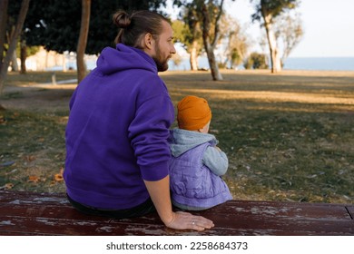 Dad and child are walking in the autumn park. Mediterranean climate. - Shutterstock ID 2258684373