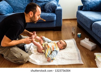 Dad Cleaning His Baby's Dirty Ass, Changing The Stinky Diaper With A Nose Clip, Fatherhood And Humor.