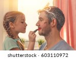 dad with cute daughter beeing treated with lipstick for carnival