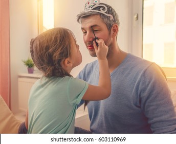 dad with cute daughter beeing treated with lipstick for carnival - Powered by Shutterstock