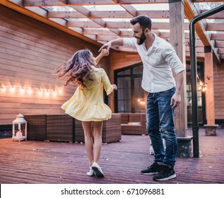 Dad Is Dancing With His Daughter On House's Terrace.