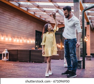 Dad Is Dancing With His Daughter On House's Terrace.