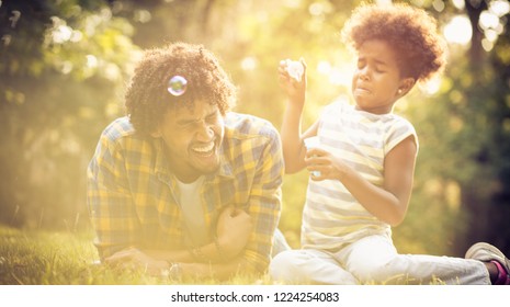 Dad And Daughter Are Always Fun Best. African American Daughter And Her Father Playing With Water Balloons In Park. Close Up.