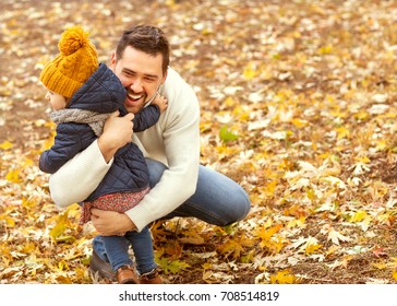 Papa und Tochter im Herbstpark lachen