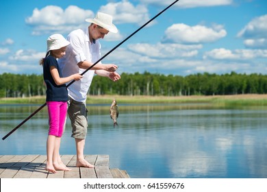Dad and daughter caught a fish in a bait in the lake - Powered by Shutterstock