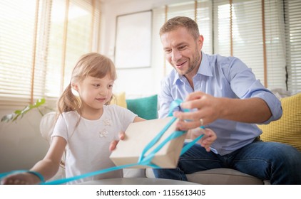 Dad And Daughter Are Excited About Opening The Gift Box. Setup Studio Shooting.