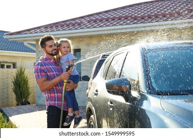 Dad and daughter washing car at backyard on sunny day - Powered by Shutterstock