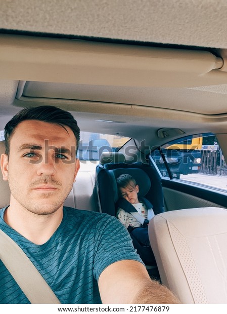 Dad driving a car with a small child in a child
seat behind