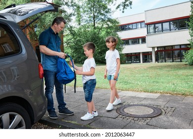 Dad, Father Sees Off, Leads The Children To School, Brother And Sister, Boy And Girl, Takes Backpacks Out Of The Car. School Days, The Beginning Of The School Day