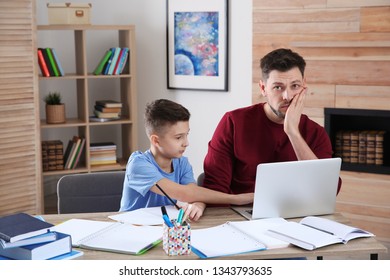 Dad Helping His Son With Difficult Homework Assignment In Room, Space For Text