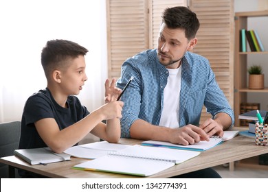 Dad Helping His Son With Homework In Room