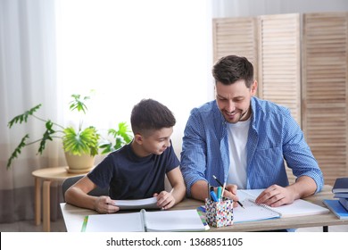 Dad Helping His Son With Homework In Room