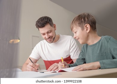 Dad Helping His Son With School Assignment At Home