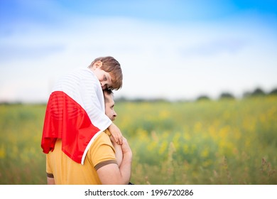 Dad with his little son on his shoulders walking in the field covered with flag of Poland. Father's day in Poland. Polish Flag Day. Independence Day. Love Poland, travel concept. Selective focus. - Shutterstock ID 1996720286
