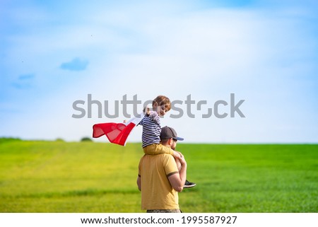 Dad with his little son walking in the field holding flag of Poland. Fathers day in Poland. Polish Flag Day. Independence Day. Love Poland, travel and learn polish language concept.