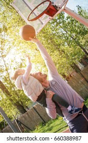 Dad And His Son Playing Basketball Together. Enjoying In Spring Day. Father Raised His Son In The Air.