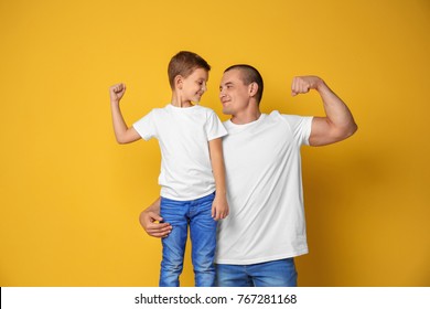 Dad And His Son Showing Muscles On Color Background