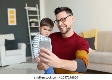 Dad and his son taking selfie at home - Shutterstock ID 1057196804