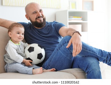 Dad and his son watching football at home