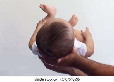 Dad Holding 6-month-old Baby Boy Against The White Background. Father Picking Up His Baby. Free Space. Family Concept