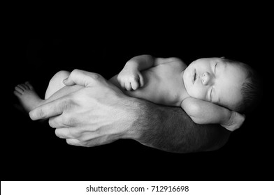 Dad Holding His Newborn Baby In His Hand. Baby Lying On His Father's Arm. Father Caring For His Baby. 